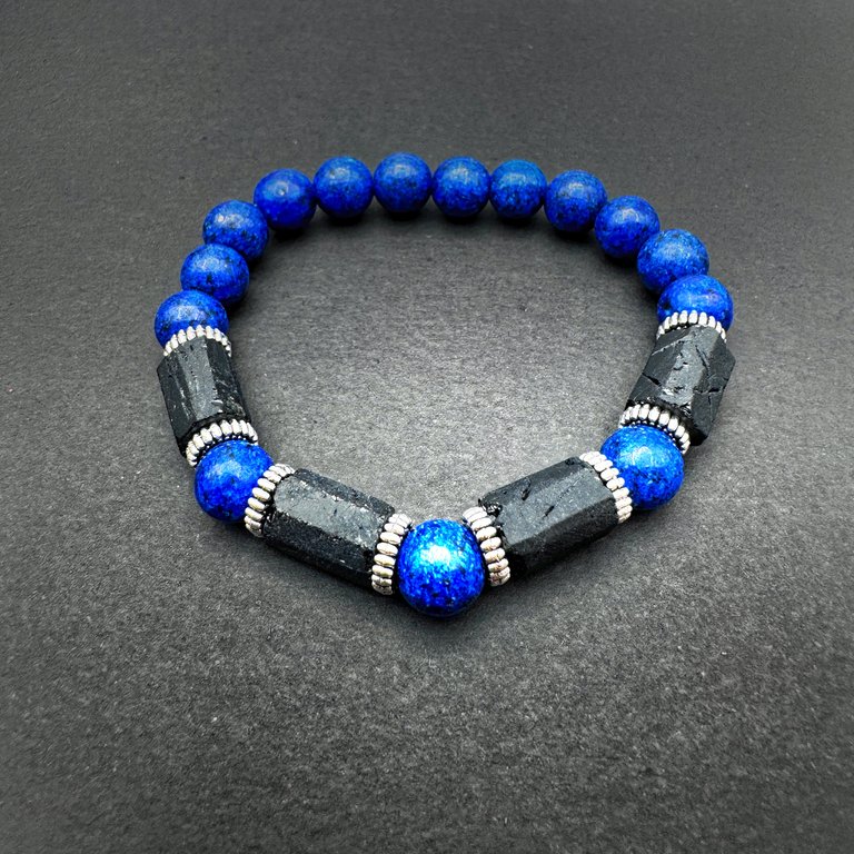 Psychic Protection Bracelet with blue beads and black sections on dark slate